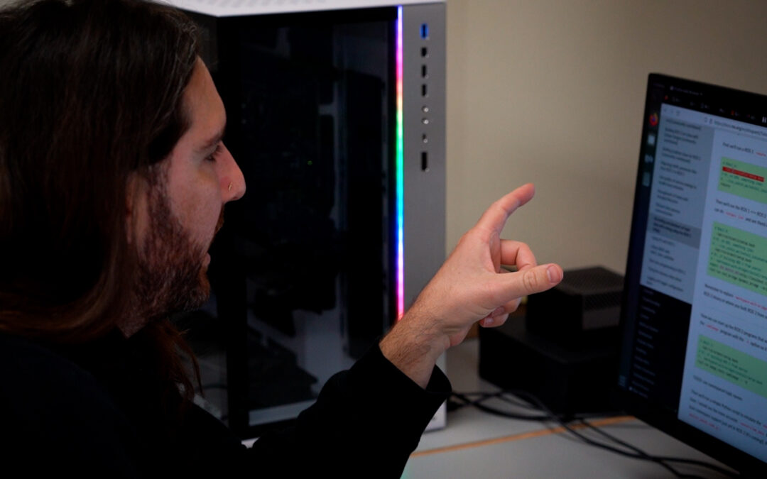 A man points at a screen with computer code