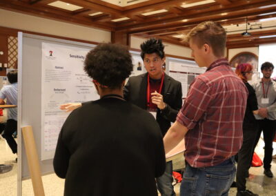 Student explains his astronomy research to two audience members