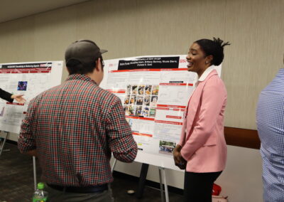 Student explains her cancer chemistry research to a professor