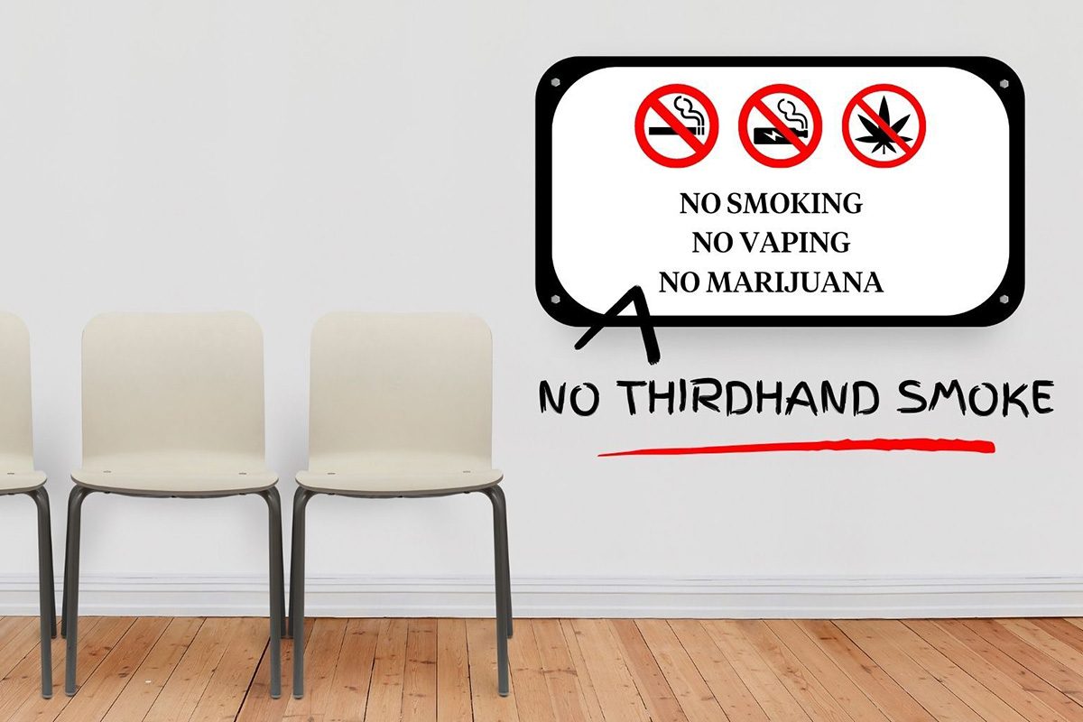 ThirdhandSmoke-1200 A room that contains three chairs and a sign that reads “NO SMOKING NO VAPING NO MARIJUANA” with a hand-drawn caret adding the words “NO THIRDHAND SMOKE,” underlined in red.
